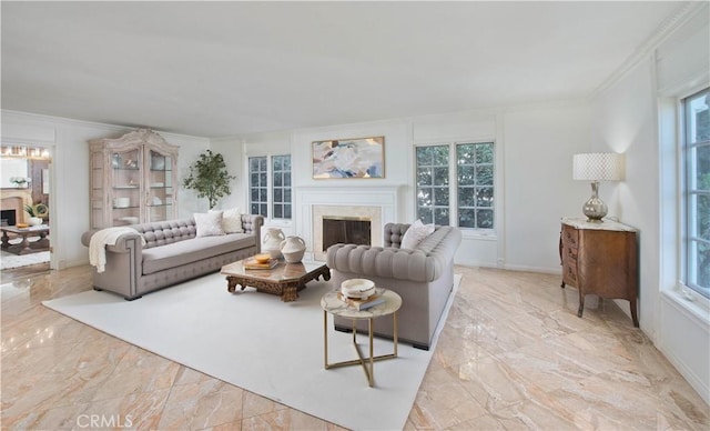 living room featuring plenty of natural light, marble finish floor, a fireplace, and crown molding