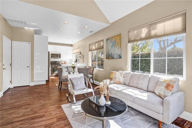 living area featuring dark wood-type flooring, recessed lighting, visible vents, and baseboards