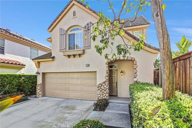 mediterranean / spanish house featuring an attached garage, fence, a tile roof, driveway, and stucco siding