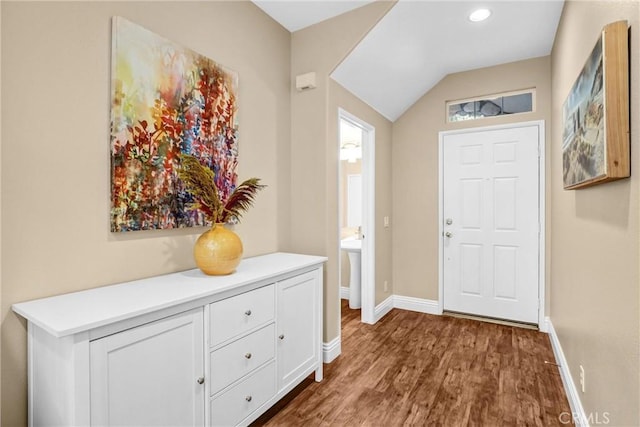 entrance foyer featuring lofted ceiling, dark wood-style flooring, and baseboards