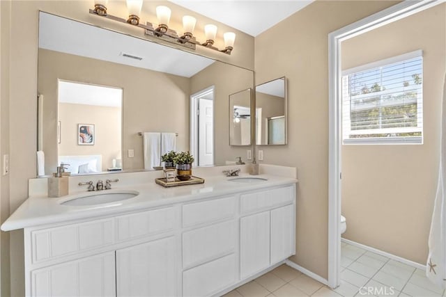 full bath featuring toilet, double vanity, visible vents, and a sink