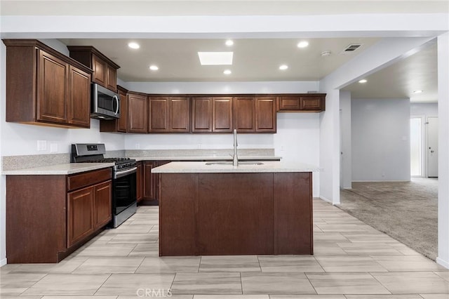 kitchen with visible vents, an island with sink, stainless steel appliances, a sink, and recessed lighting