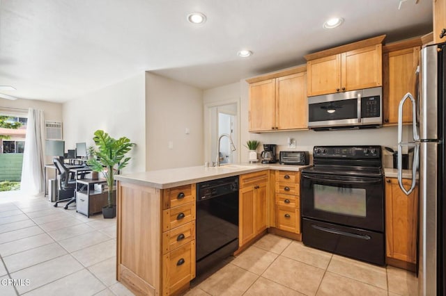 kitchen featuring light countertops, light tile patterned flooring, a sink, a peninsula, and black appliances