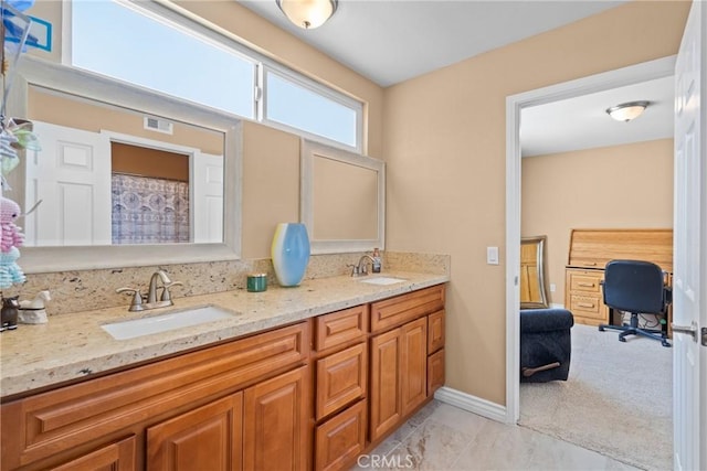 bathroom featuring double vanity, visible vents, baseboards, and a sink