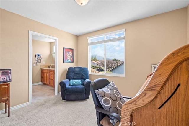 sitting room with baseboards and light colored carpet