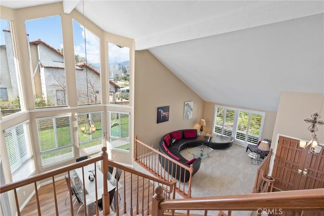 living room with beam ceiling, a notable chandelier, wood finished floors, and high vaulted ceiling