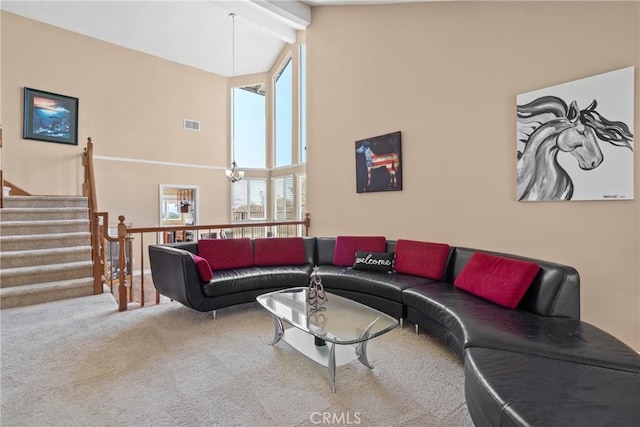 carpeted living area with visible vents, a chandelier, beamed ceiling, stairs, and high vaulted ceiling