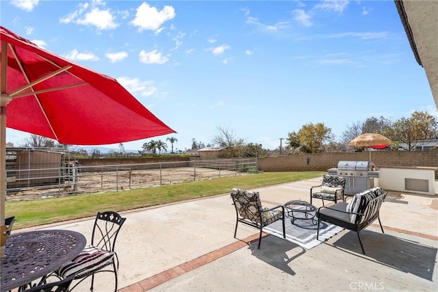 view of patio featuring a grill and fence