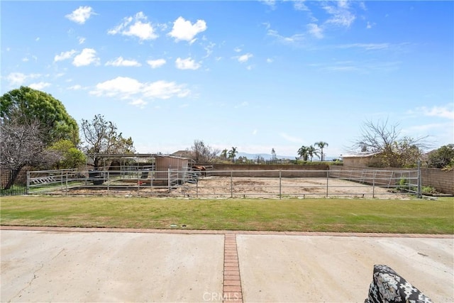 view of yard featuring an exterior structure, a rural view, and an outdoor structure