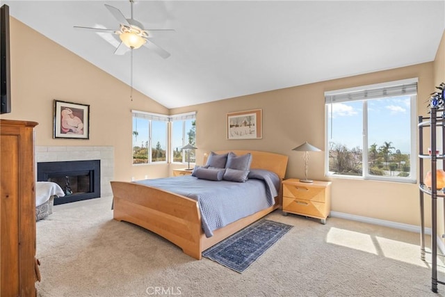 bedroom with a tiled fireplace, carpet flooring, baseboards, and lofted ceiling