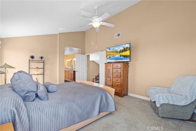 bedroom with high vaulted ceiling, visible vents, baseboards, light colored carpet, and ensuite bath