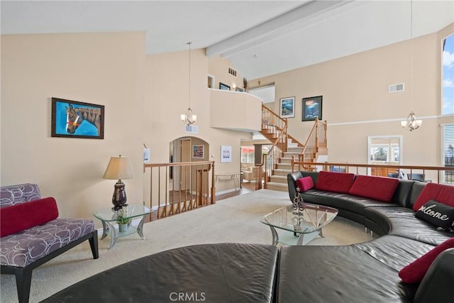 living area with a chandelier, beamed ceiling, high vaulted ceiling, and visible vents