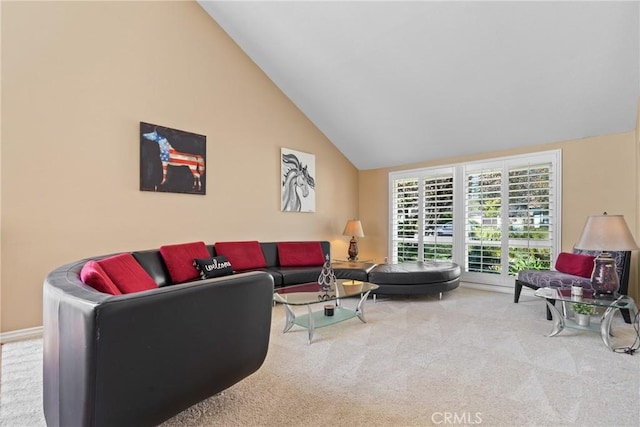 carpeted living room with high vaulted ceiling