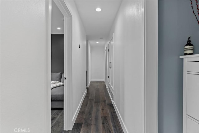 hallway featuring baseboards, dark wood-type flooring, and recessed lighting