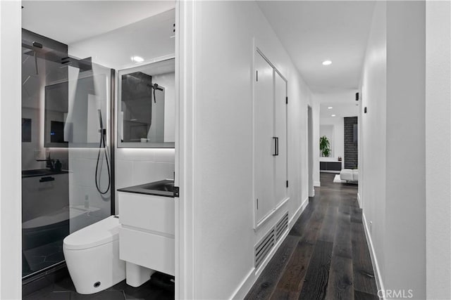 hallway featuring recessed lighting, dark wood-style flooring, visible vents, and baseboards