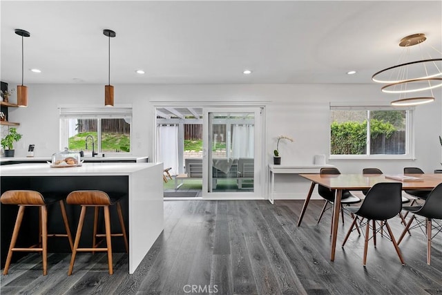 dining room with recessed lighting, a healthy amount of sunlight, and dark wood finished floors