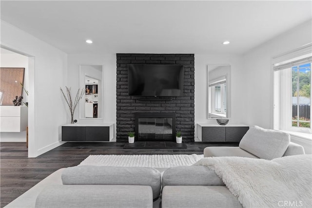 living room featuring baseboards, a fireplace, wood finished floors, and recessed lighting