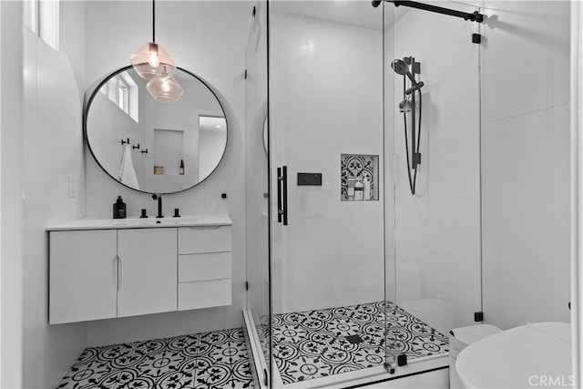 bathroom with a stall shower, tile walls, vanity, and toilet