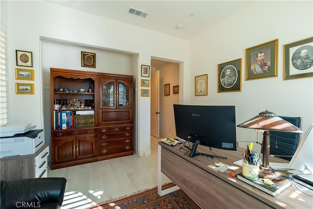 home office featuring visible vents and wood finished floors