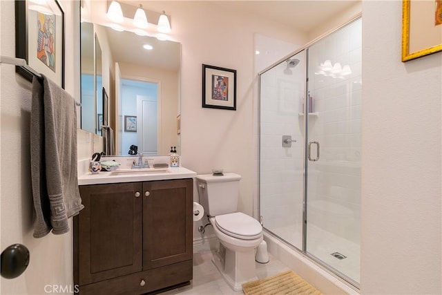 bathroom featuring toilet, a stall shower, and vanity