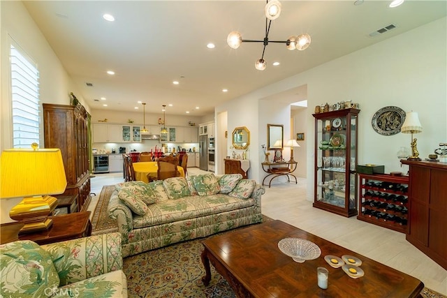 living area with recessed lighting, beverage cooler, visible vents, and light wood-style flooring