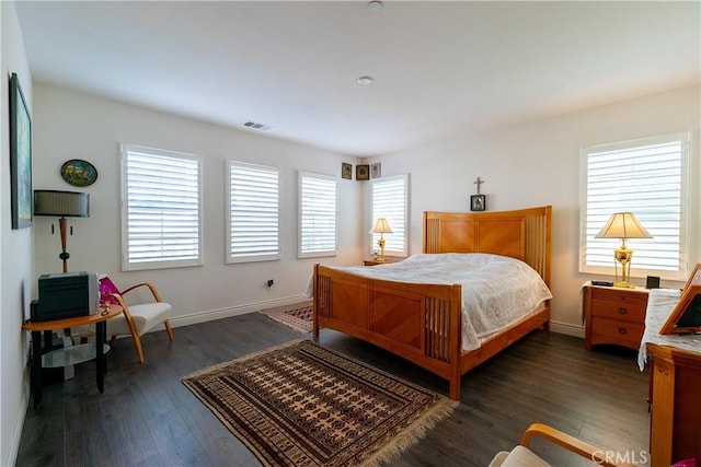 bedroom featuring wood finished floors, visible vents, and baseboards