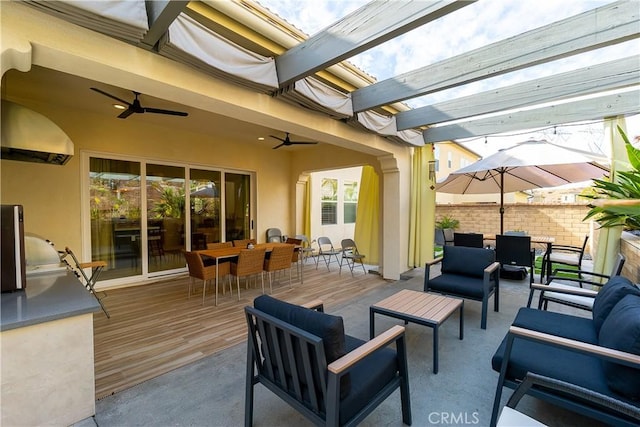 view of patio featuring an outdoor hangout area, outdoor dining space, ceiling fan, fence, and a pergola