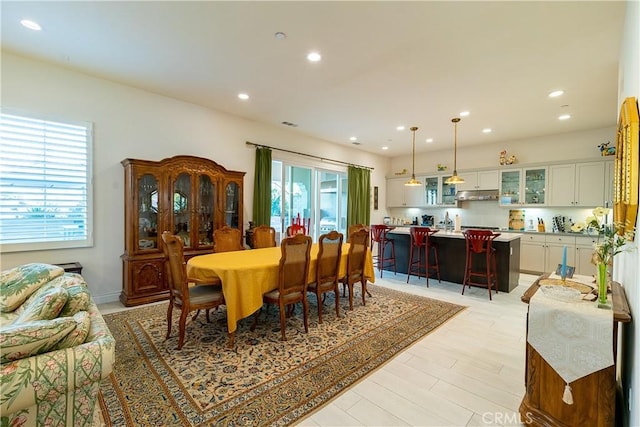 dining area with light wood-type flooring, a wealth of natural light, and recessed lighting