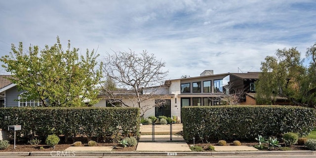 view of front of house featuring a fenced front yard and a chimney