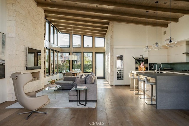 living room featuring a high ceiling, beam ceiling, wooden ceiling, and dark wood-style flooring