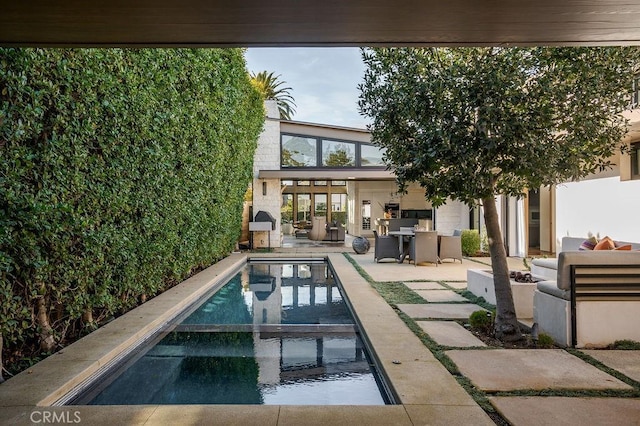 view of pool with outdoor dining space, a pool with connected hot tub, a patio area, and an outdoor living space