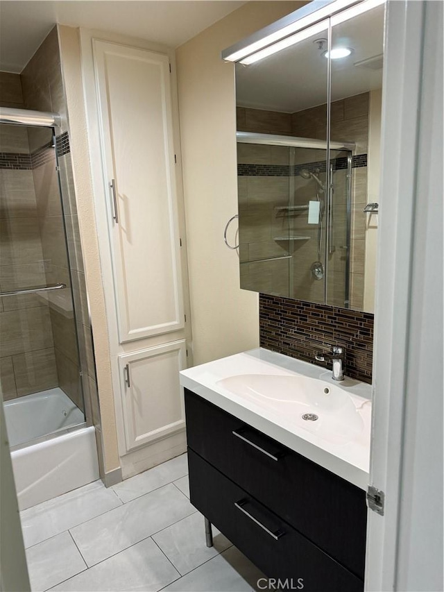 full bathroom with tasteful backsplash, combined bath / shower with glass door, tile patterned flooring, and vanity