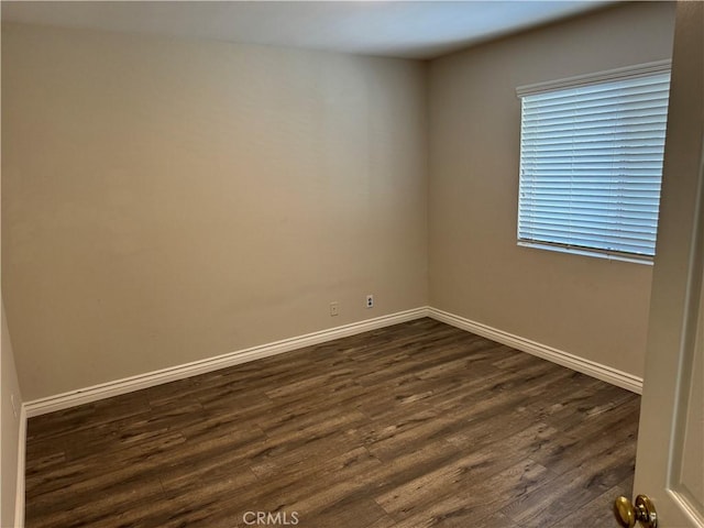 unfurnished room featuring dark wood finished floors and baseboards