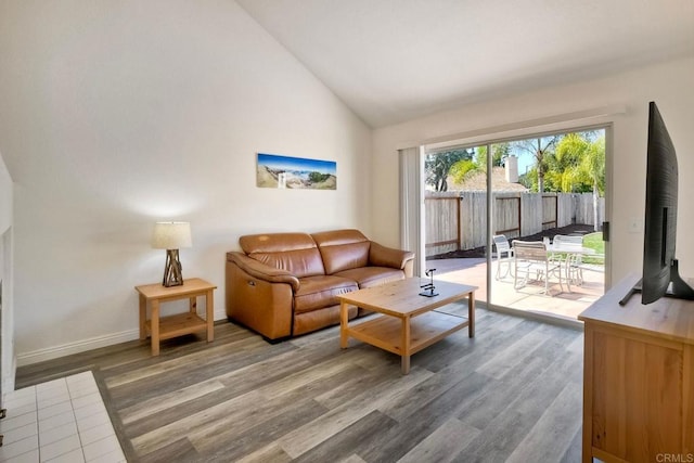 living room with high vaulted ceiling, wood finished floors, and baseboards