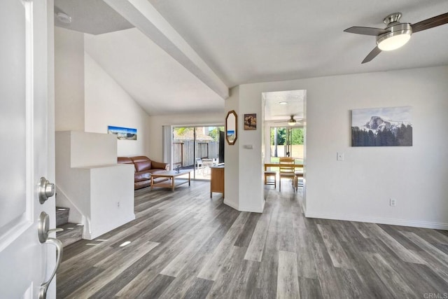 interior space featuring stairway, a ceiling fan, vaulted ceiling, wood finished floors, and baseboards