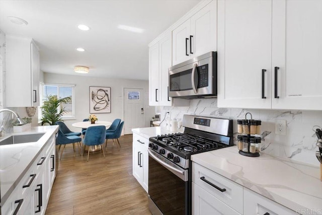 3735 Budd St, San Diego, CA 92111 - kitchen featuring light wood-style flooring, white cabinets, a sink, and appliances with stainless steel finishes
