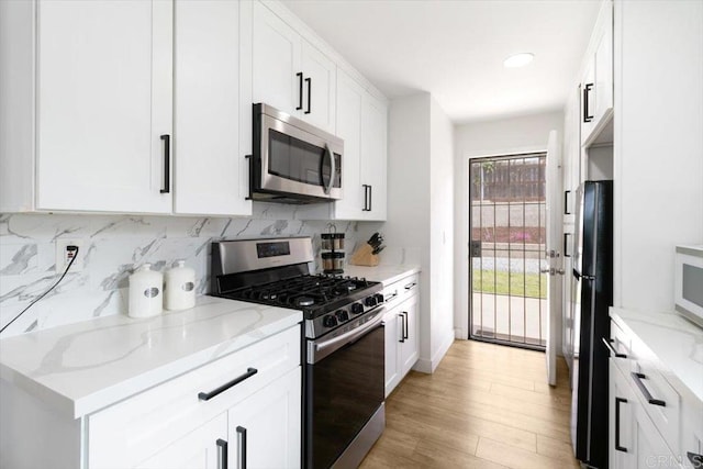 3735 Budd St, San Diego, CA 92111 - kitchen featuring white cabinetry, appliances with stainless steel finishes, light wood-style floors, and decorative backsplash