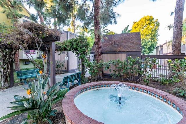 view of swimming pool featuring fence and an outbuilding