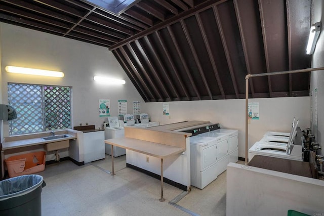 common laundry area with light floors, a sink, and washing machine and clothes dryer