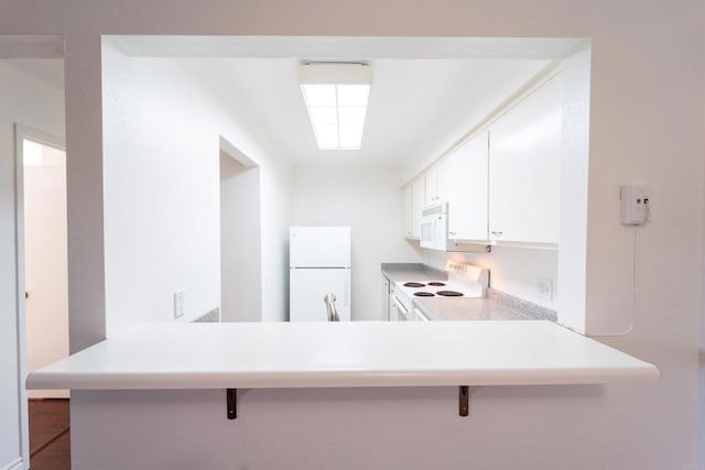 kitchen with light countertops, white cabinetry, white appliances, a peninsula, and a kitchen breakfast bar