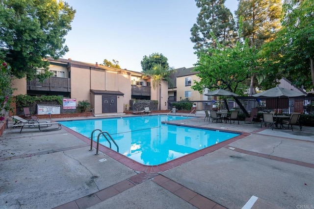 community pool with fence and a patio