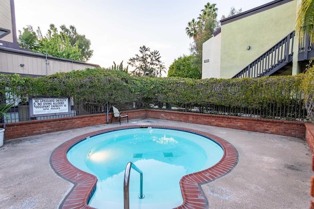 view of pool featuring a patio area, stairs, and fence