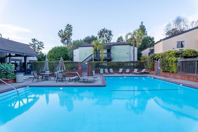 community pool featuring a patio area and fence