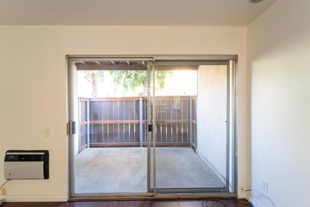 doorway featuring baseboards and heating unit