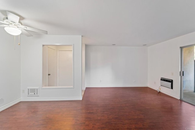 unfurnished living room with baseboards, ceiling fan, heating unit, and wood finished floors