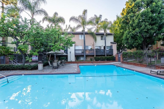 community pool featuring a patio area and fence