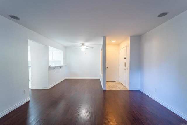 unfurnished room with ceiling fan, baseboards, and wood finished floors