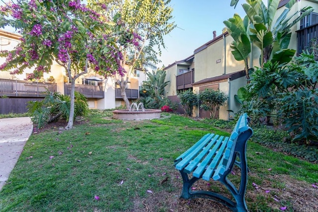 view of home's community featuring a yard and fence