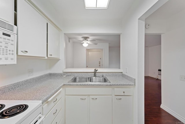 kitchen with white appliances, dark wood-style floors, light countertops, and a sink