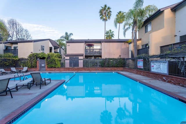 pool featuring fence and a patio